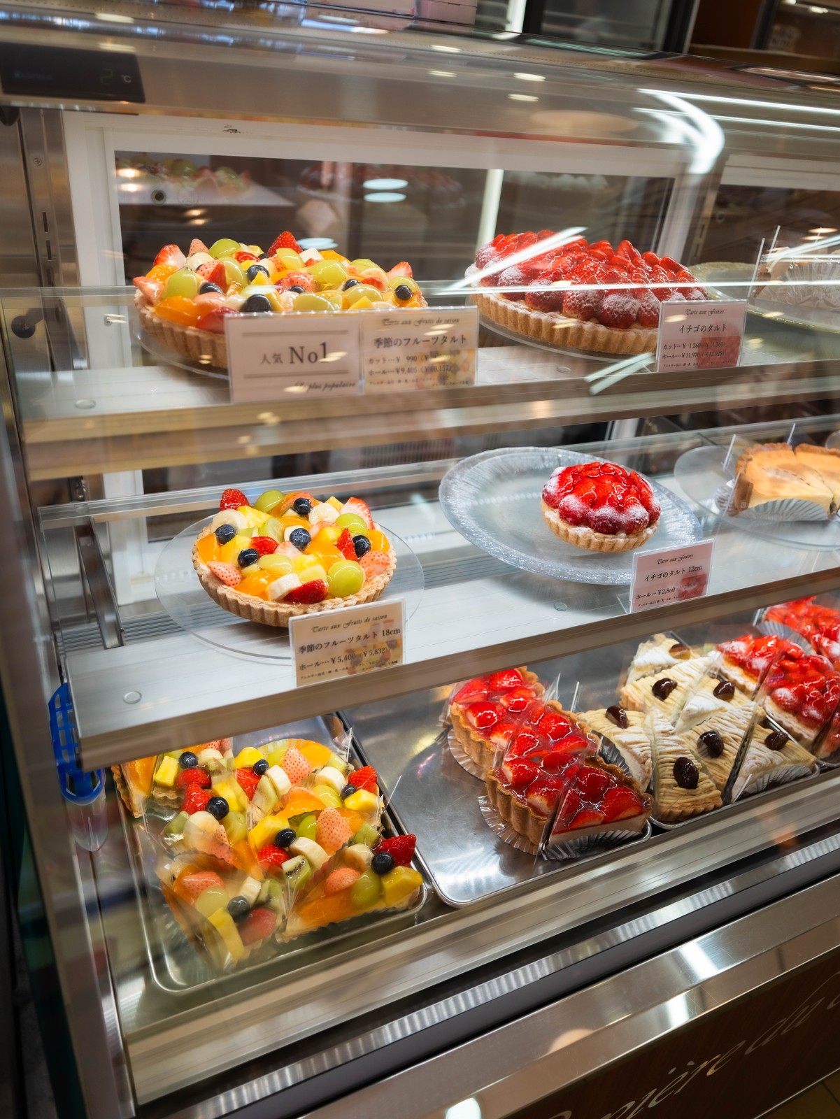 ショーケースに並ぶフルーツタルトとイチゴのタルト