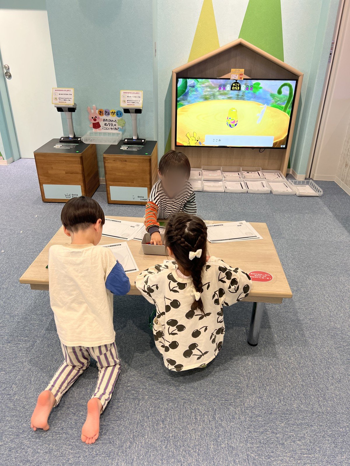 テーブルでぬりえをする子どもたち