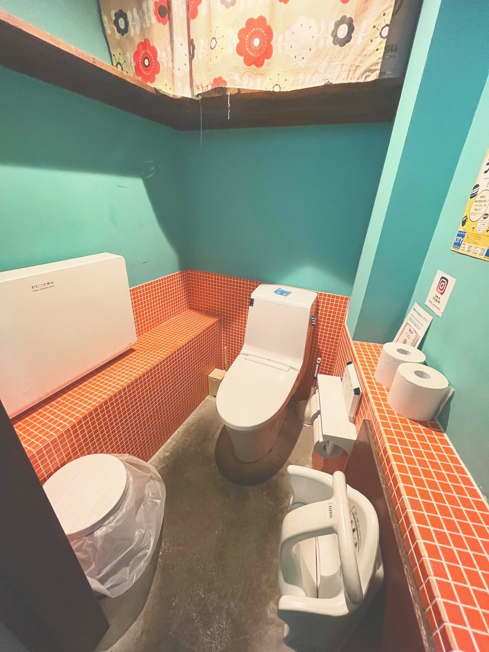トイレの壁につけられたおむつ交換台と、子ども用の椅子