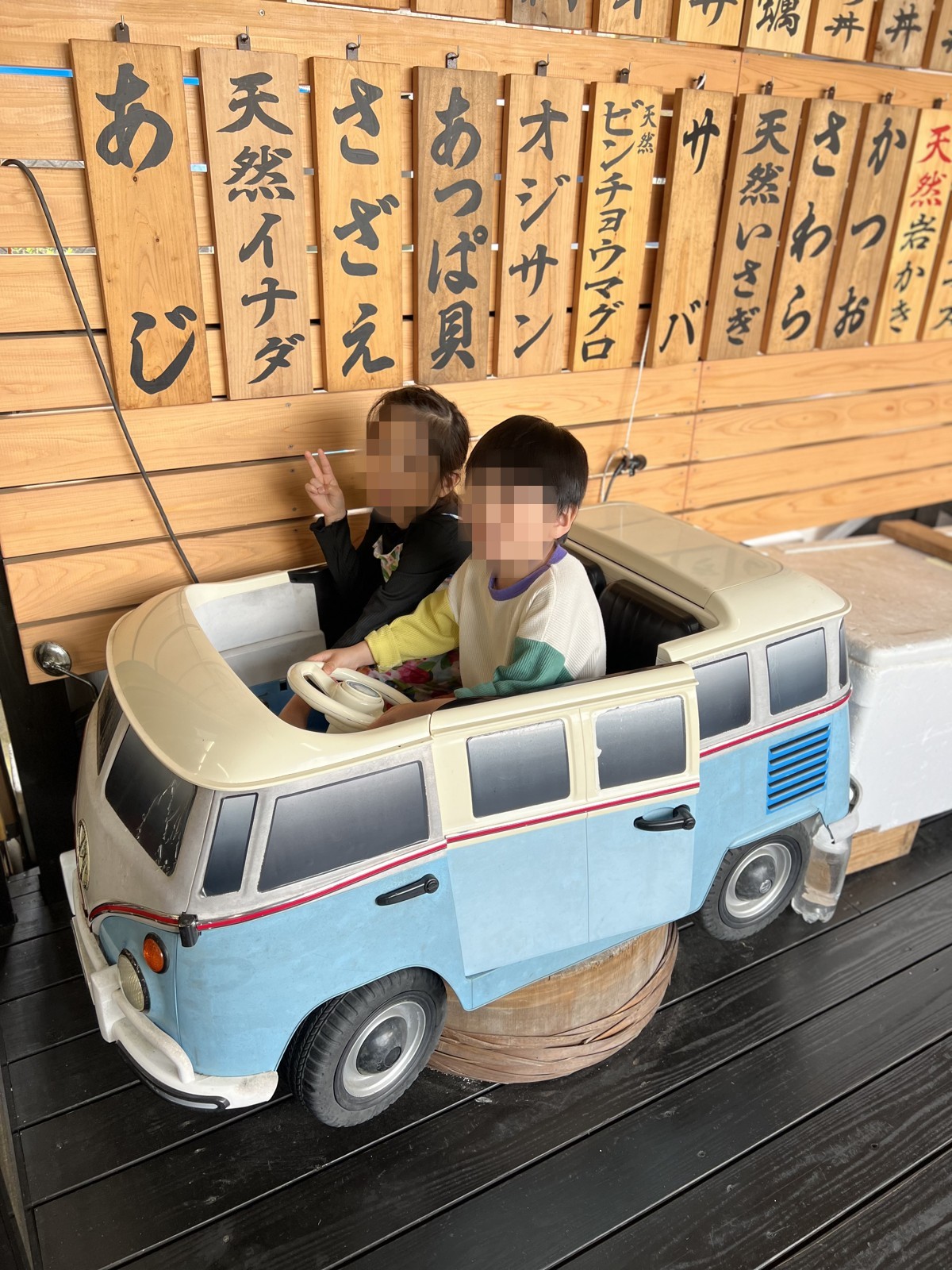 ワーゲンバスの形をした乗り物に乗る子どもたち