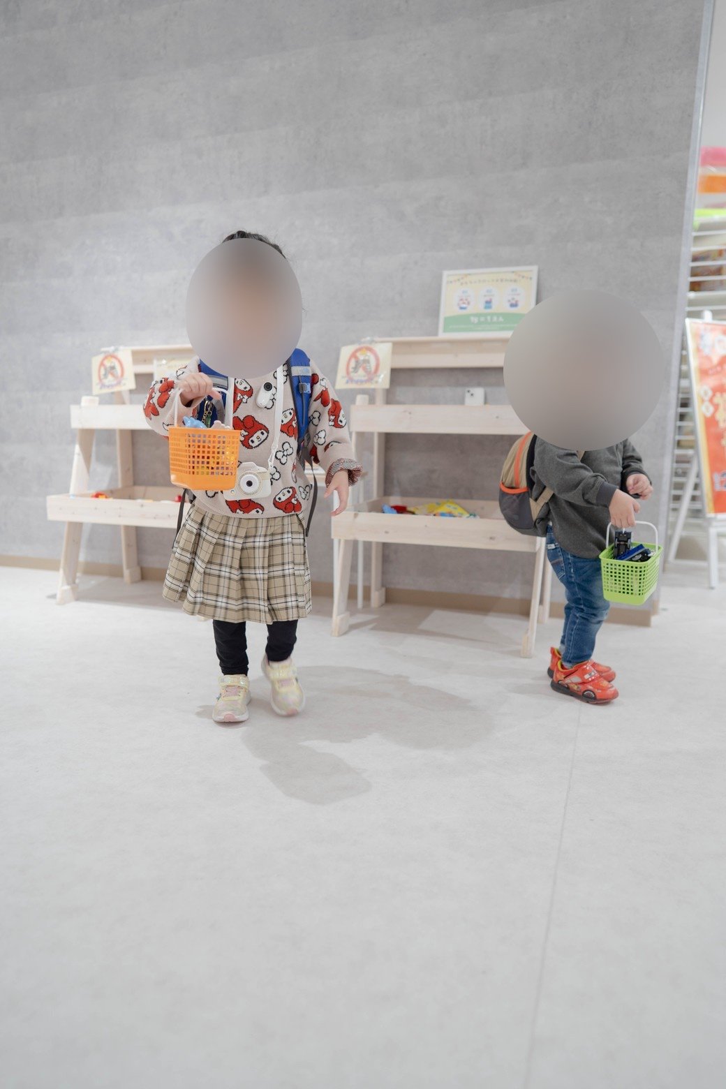 買い物かごを持って店内を歩く子どもたち