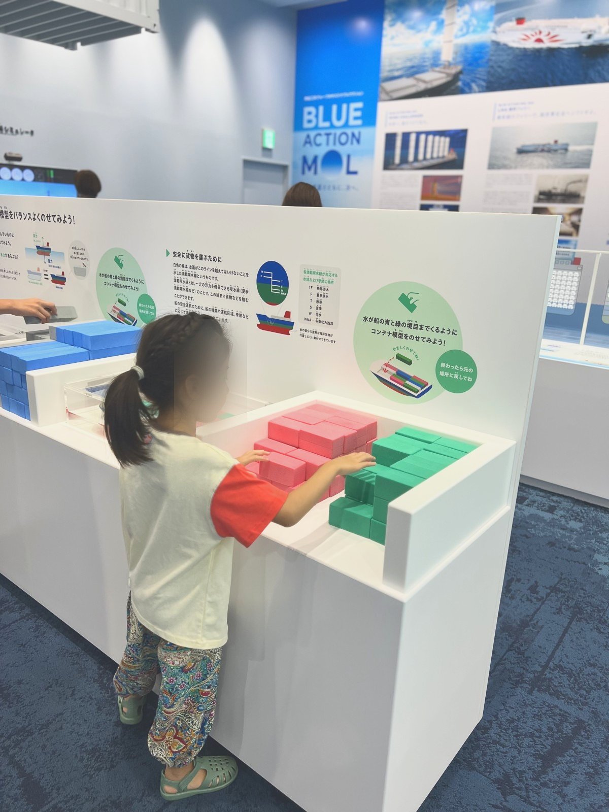 コンテナを積む展示で遊ぶ子ども