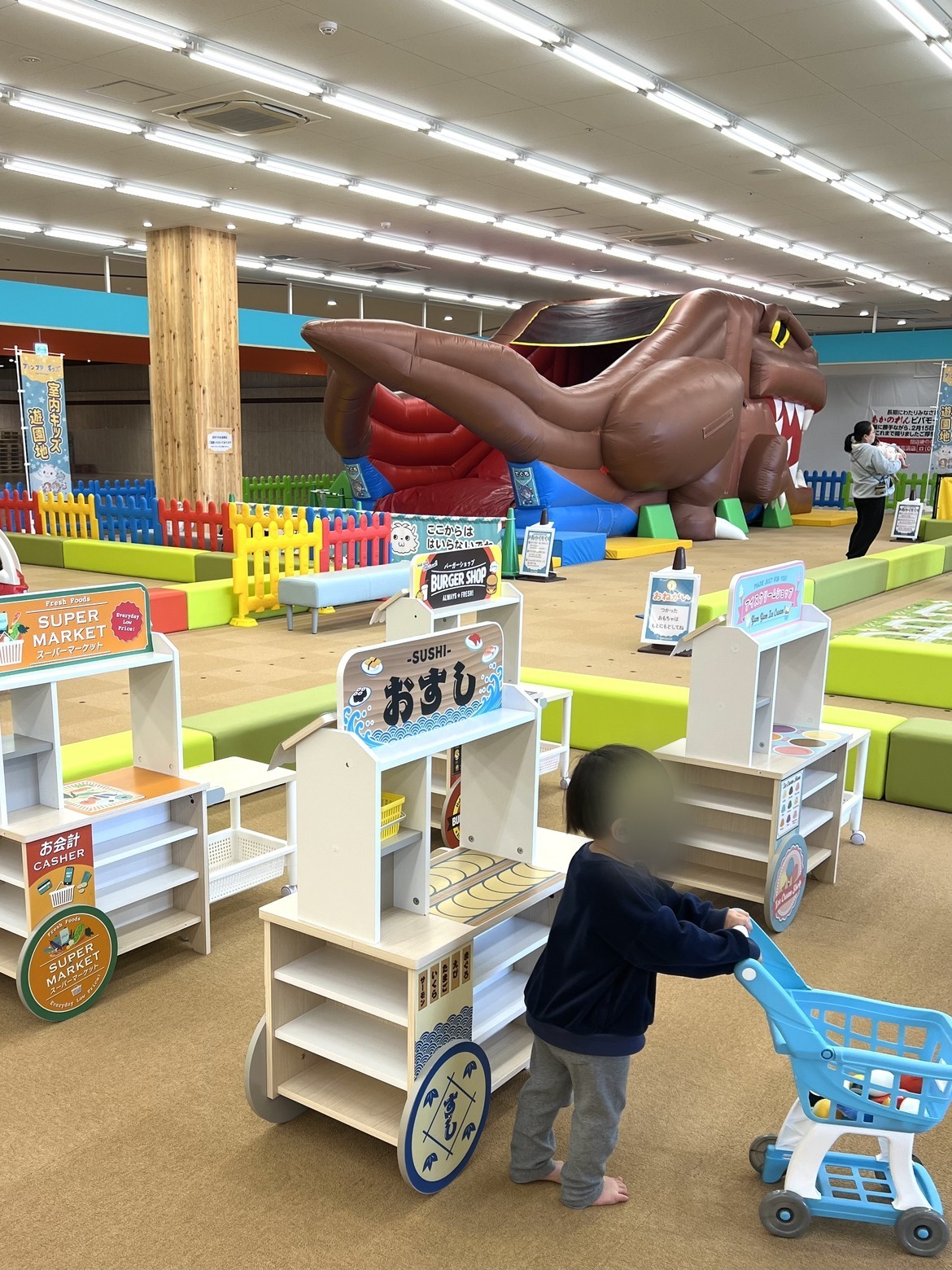 スーパーマーケットごっこのカートを押す子ども