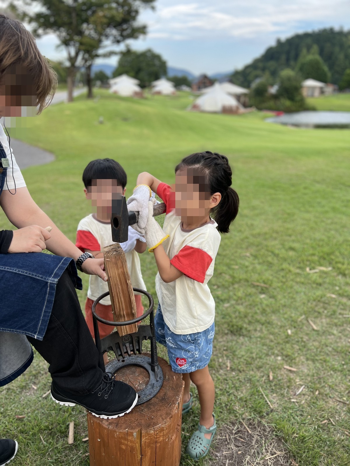 スタッフさんに教わりながら薪割りをする子どもたち