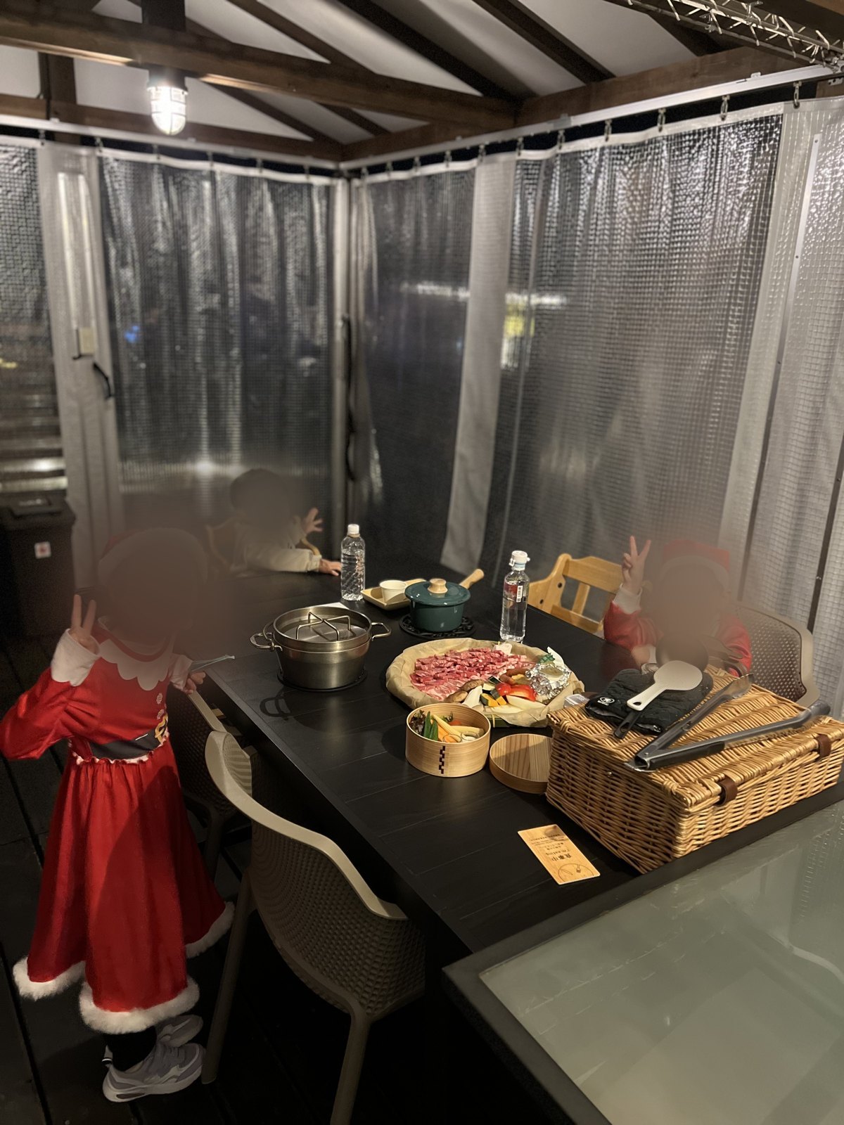 ビニールカーテンで囲まれたテラス席でBBQを待つ子どもたち