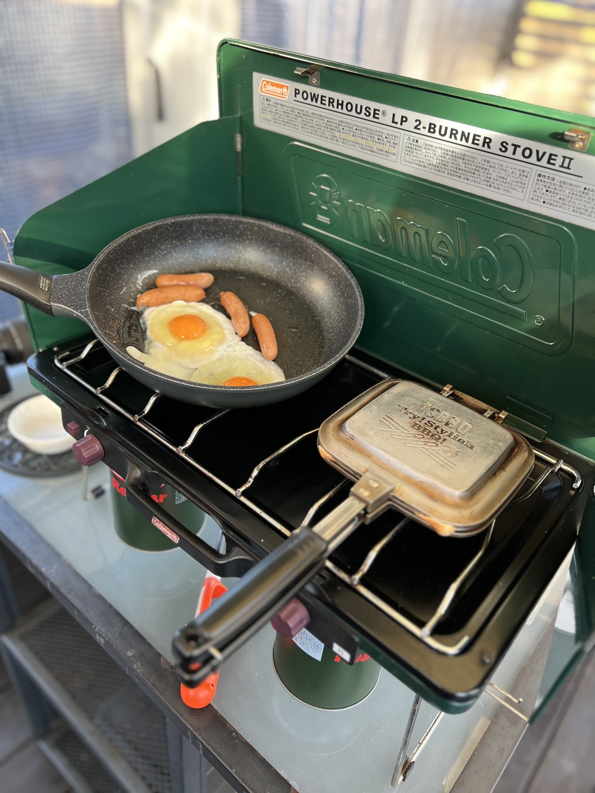 コールマンのツーバーナーで焼く目玉焼きとソーセージ、ホットサンド