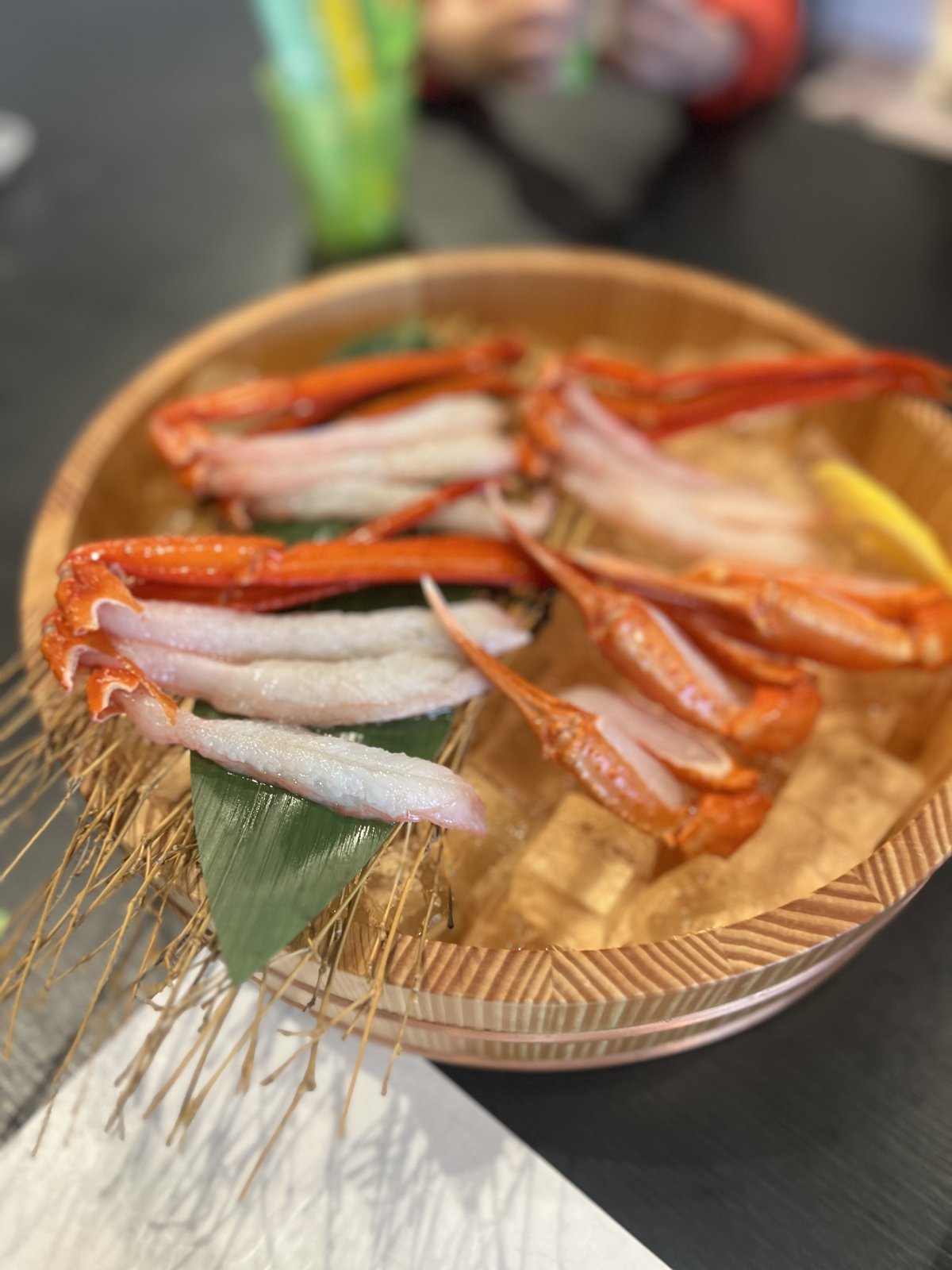 氷を入れた木の桶に盛られた、カニのお刺身
