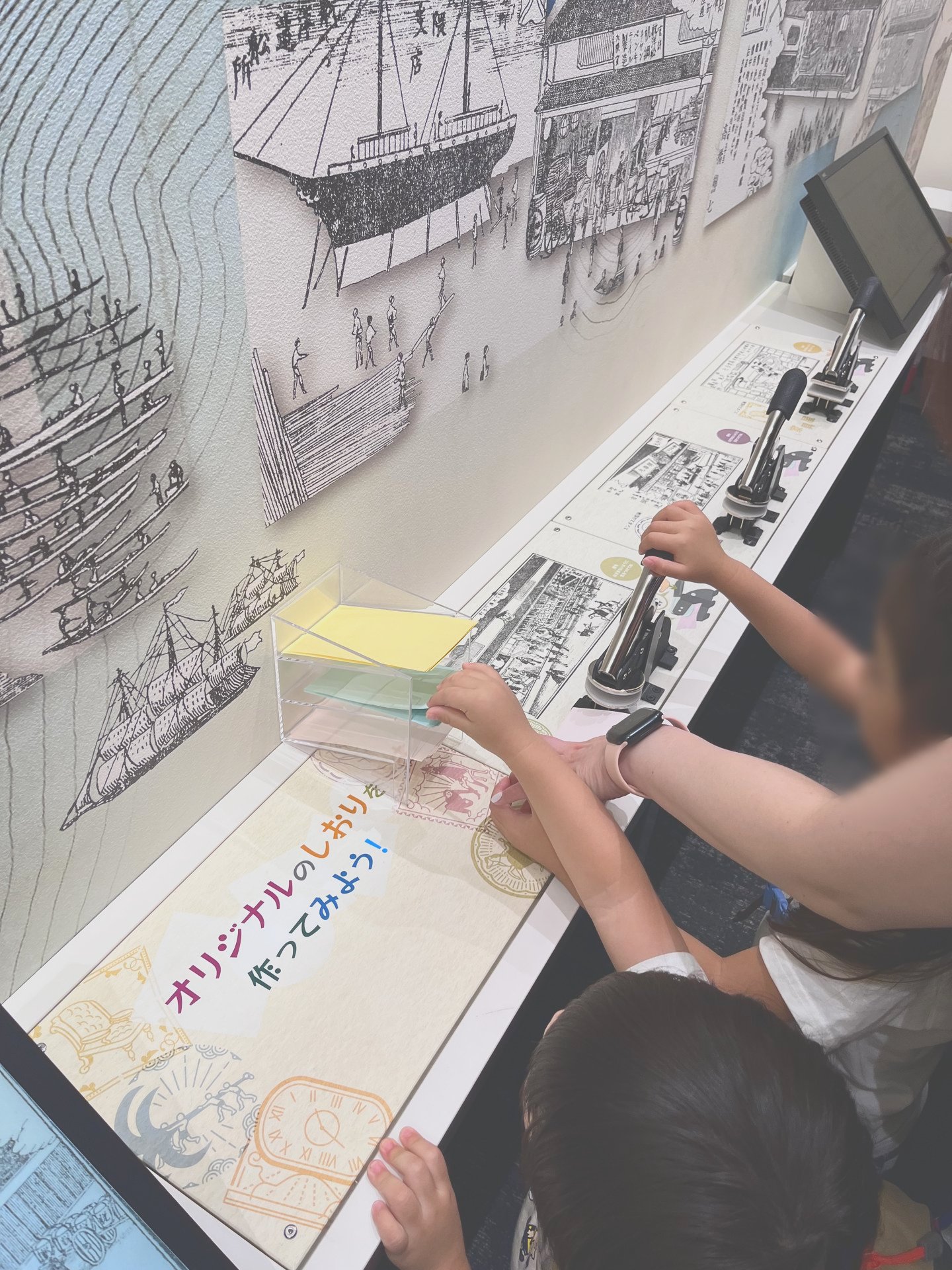 展示の操作部分に手を伸ばしている子どもたち