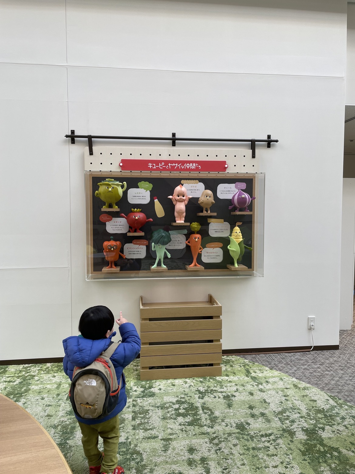 「キユーピーとヤサイな仲間たち」の展示を指さす子ども