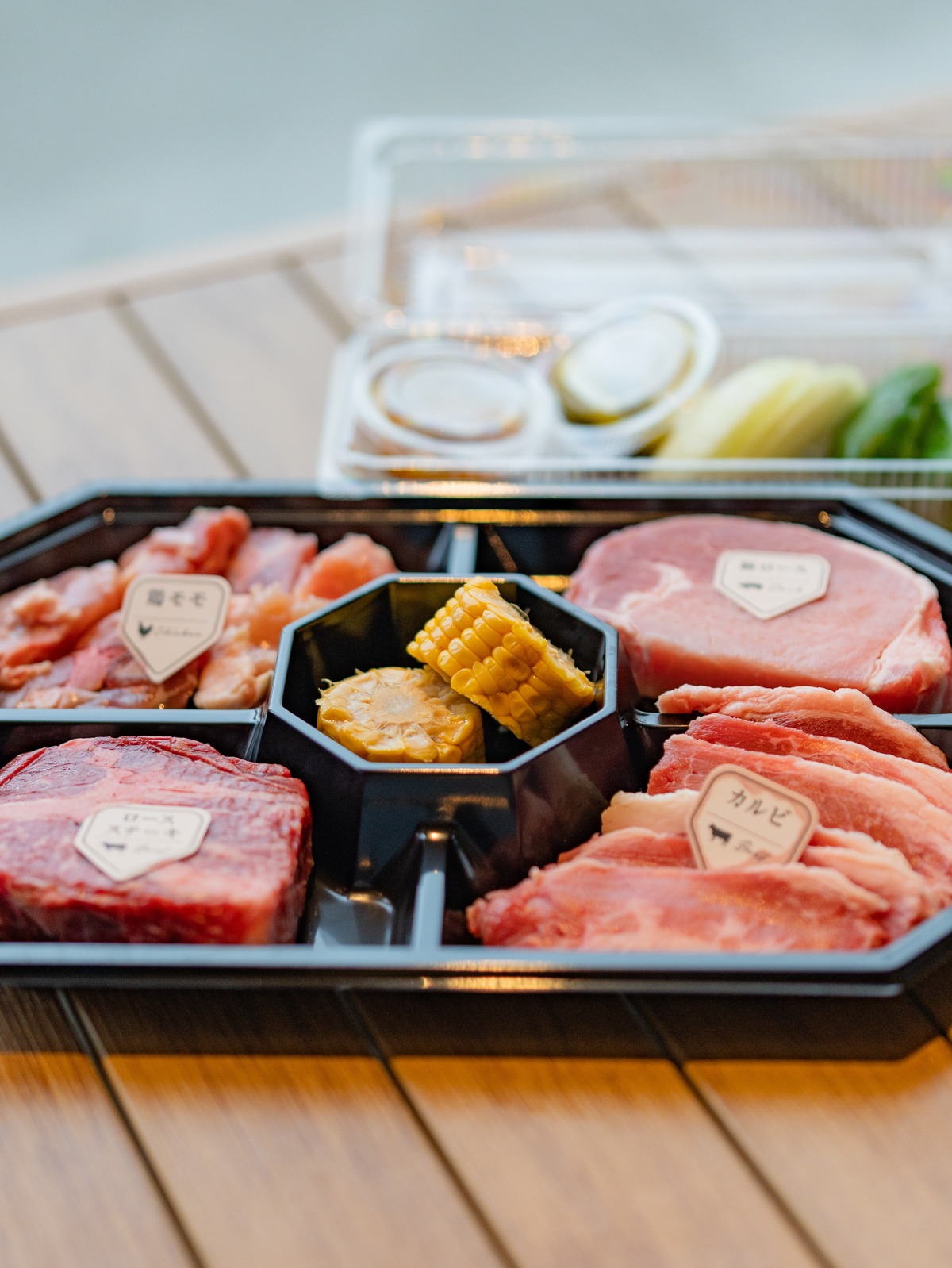 BBQの肉が盛られたトレー。鶏モモ・ロースステーキ・カルビ・とうもろこし