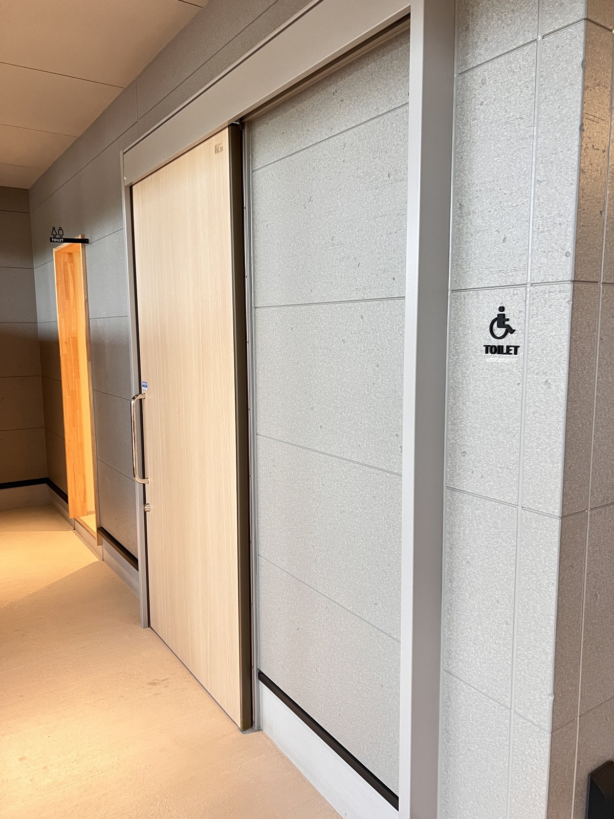 トイレの通路。「TOILET」と多目的トイレのサイン