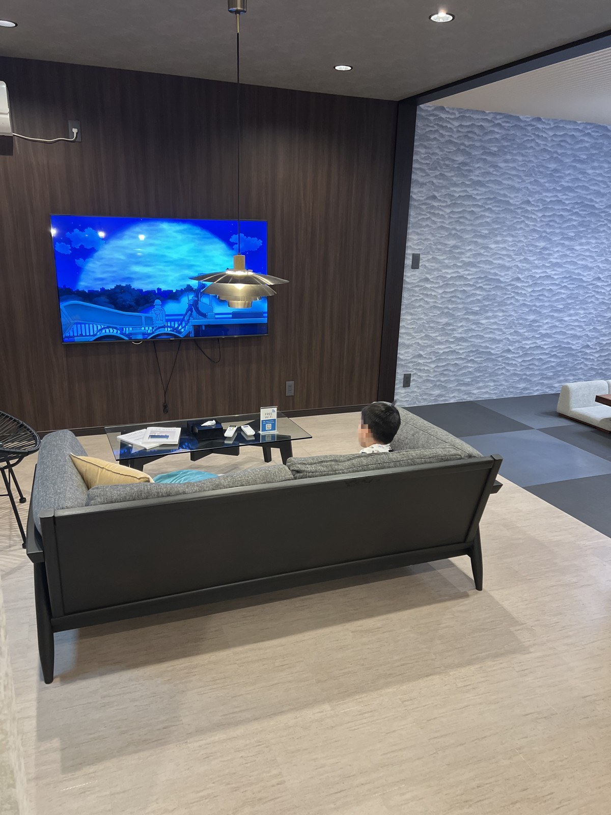 大画面テレビの前にソファが置かれたリビング