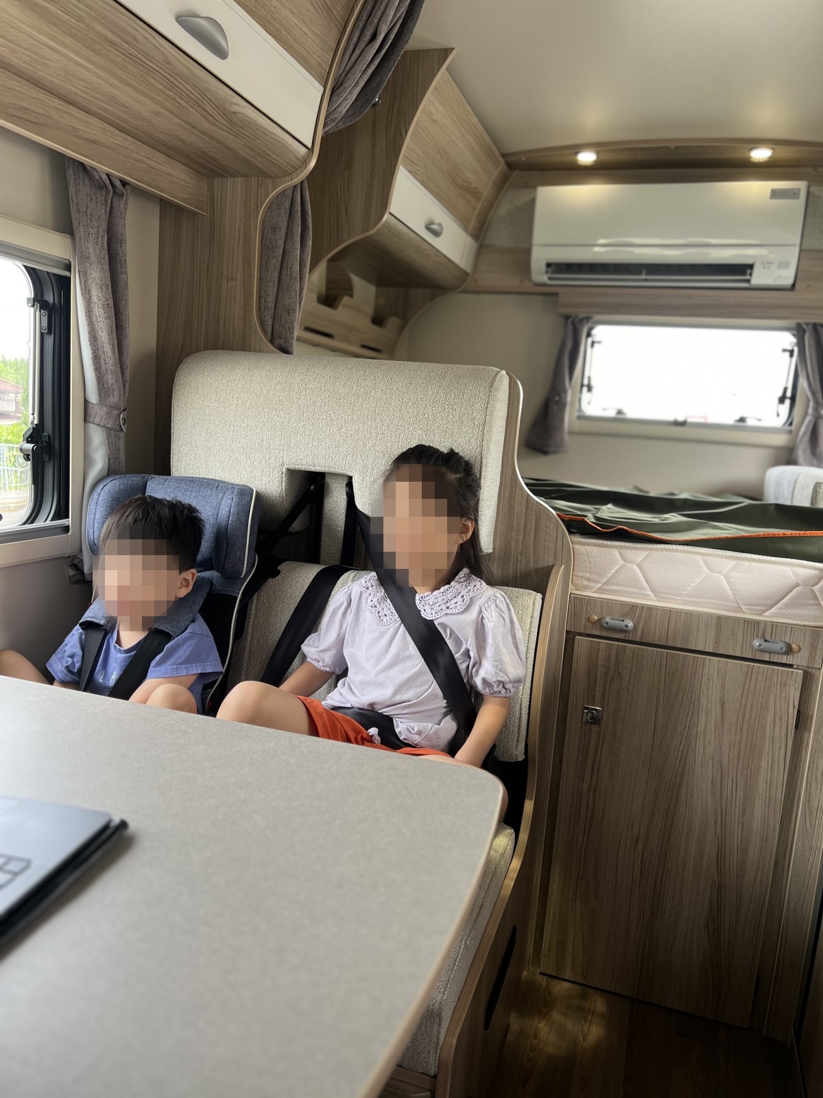 座席でシートベルトを締めている子どもたち