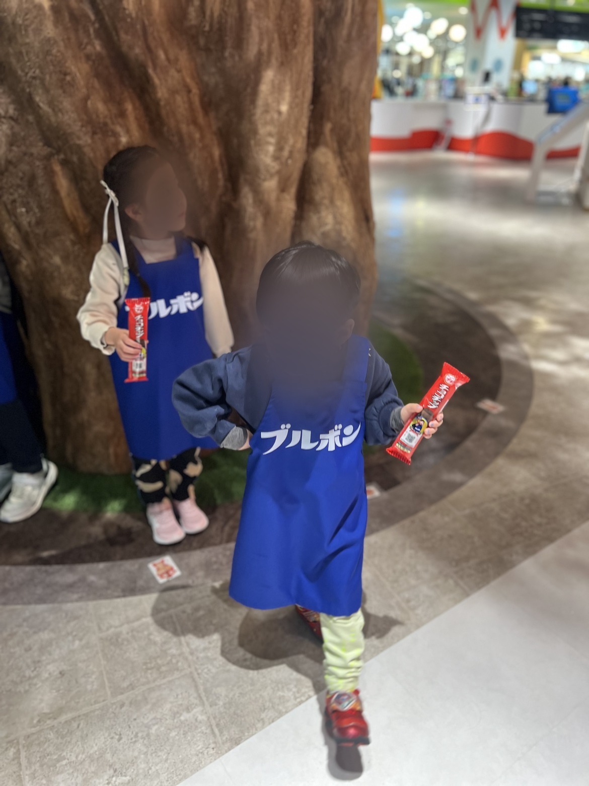 ブルボンのエプロンを着てお菓子を持つ子どもたち