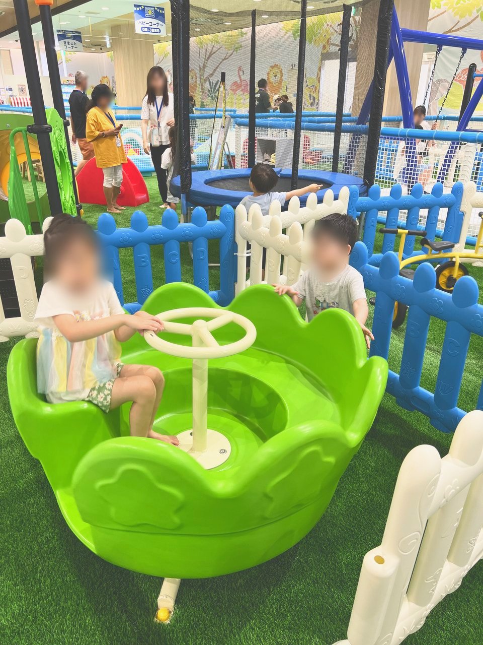 小さい子向けの柵の中にある、ハンドルを回して遊ぶ遊具