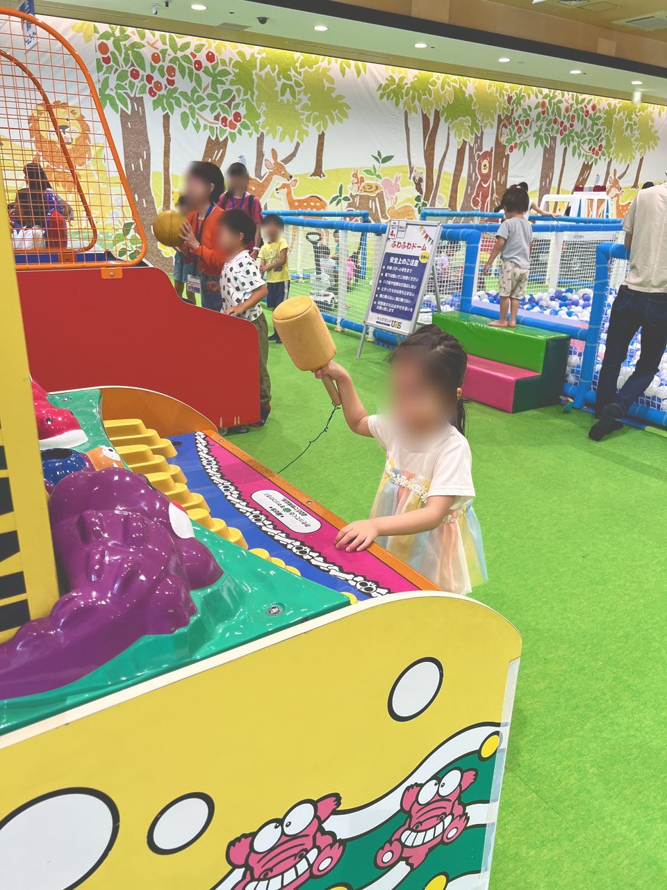 アンパンマンのゲームで遊ぶ子どもと、混雑する店内