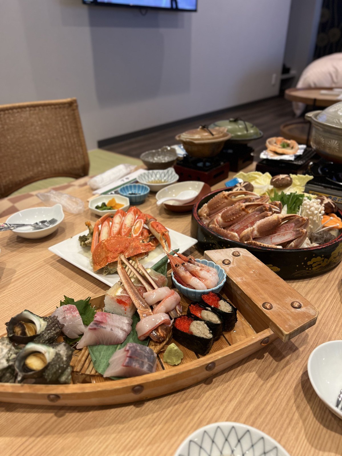 舟盛りとカニ、鍋が並ぶ夕食