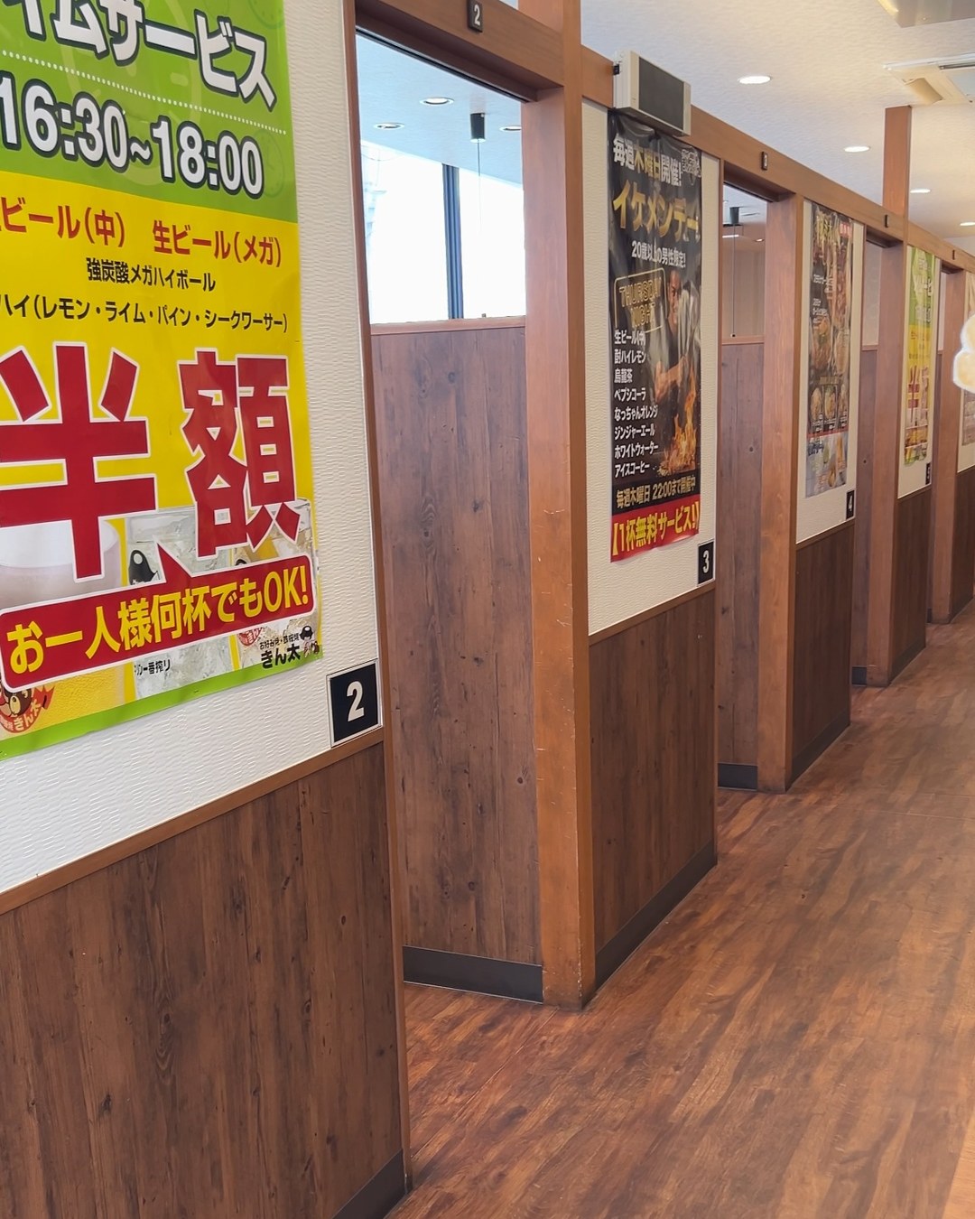 個室が並ぶ通路と、タイムサービスの案内ポスター
