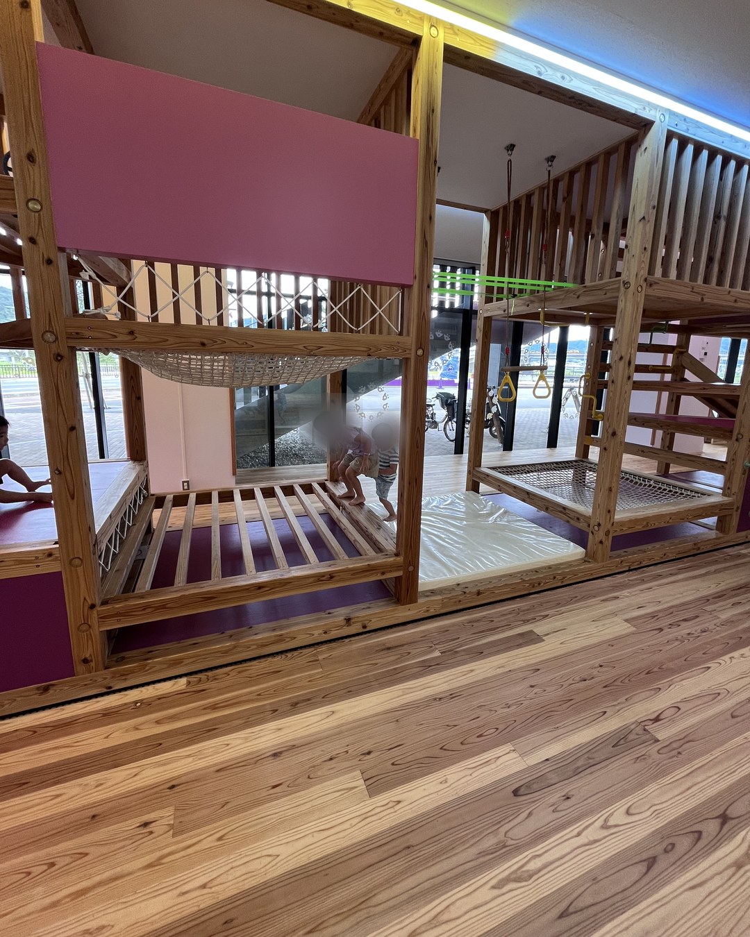 木でできた2階建ての遊具。ネットやはしごが付いている