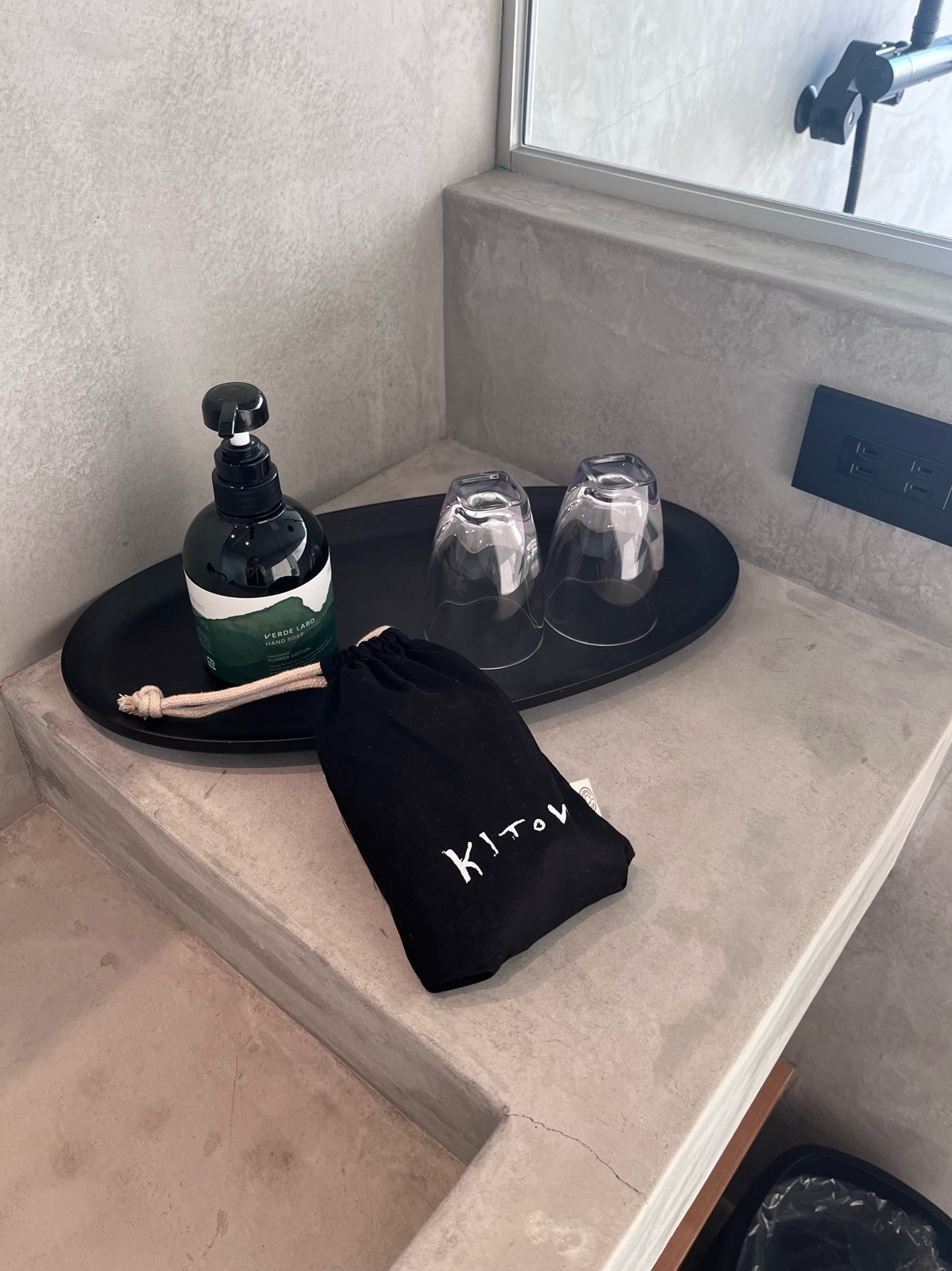 洗面台に置かれたアメニティとKITOWの巾着