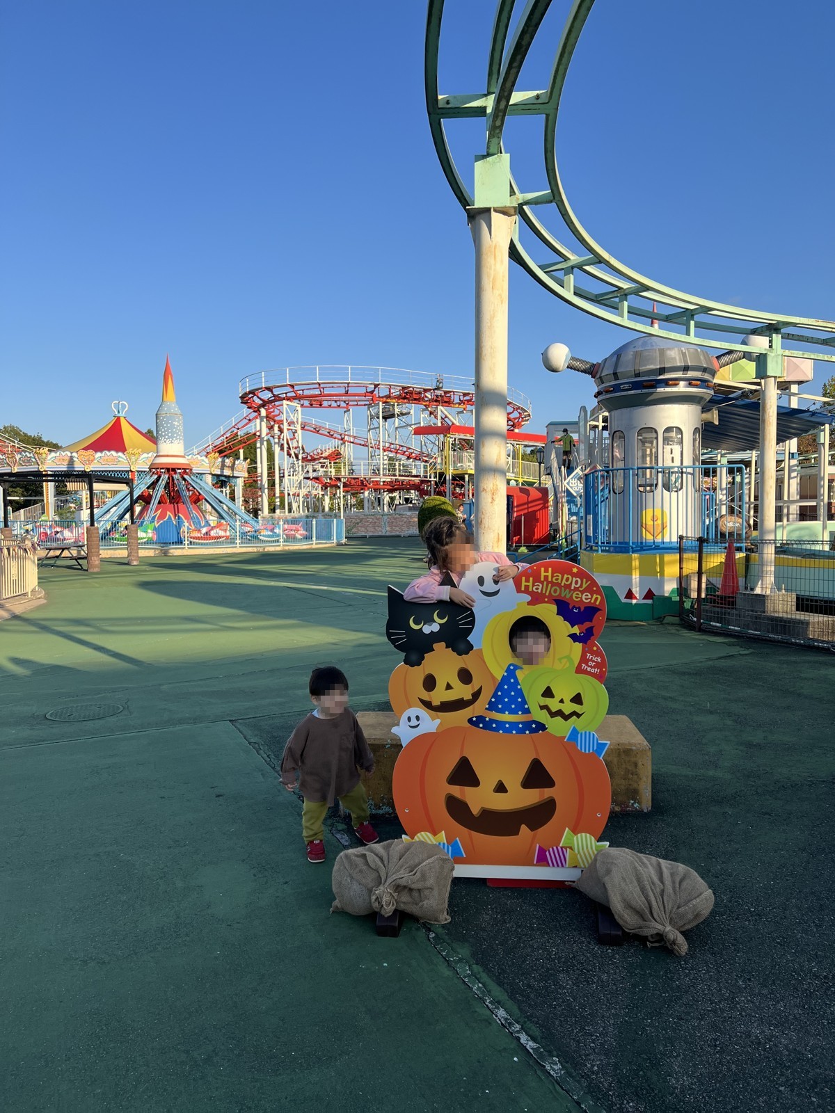観覧車やコースターが見える遊園地。手前にハロウィンのパネル