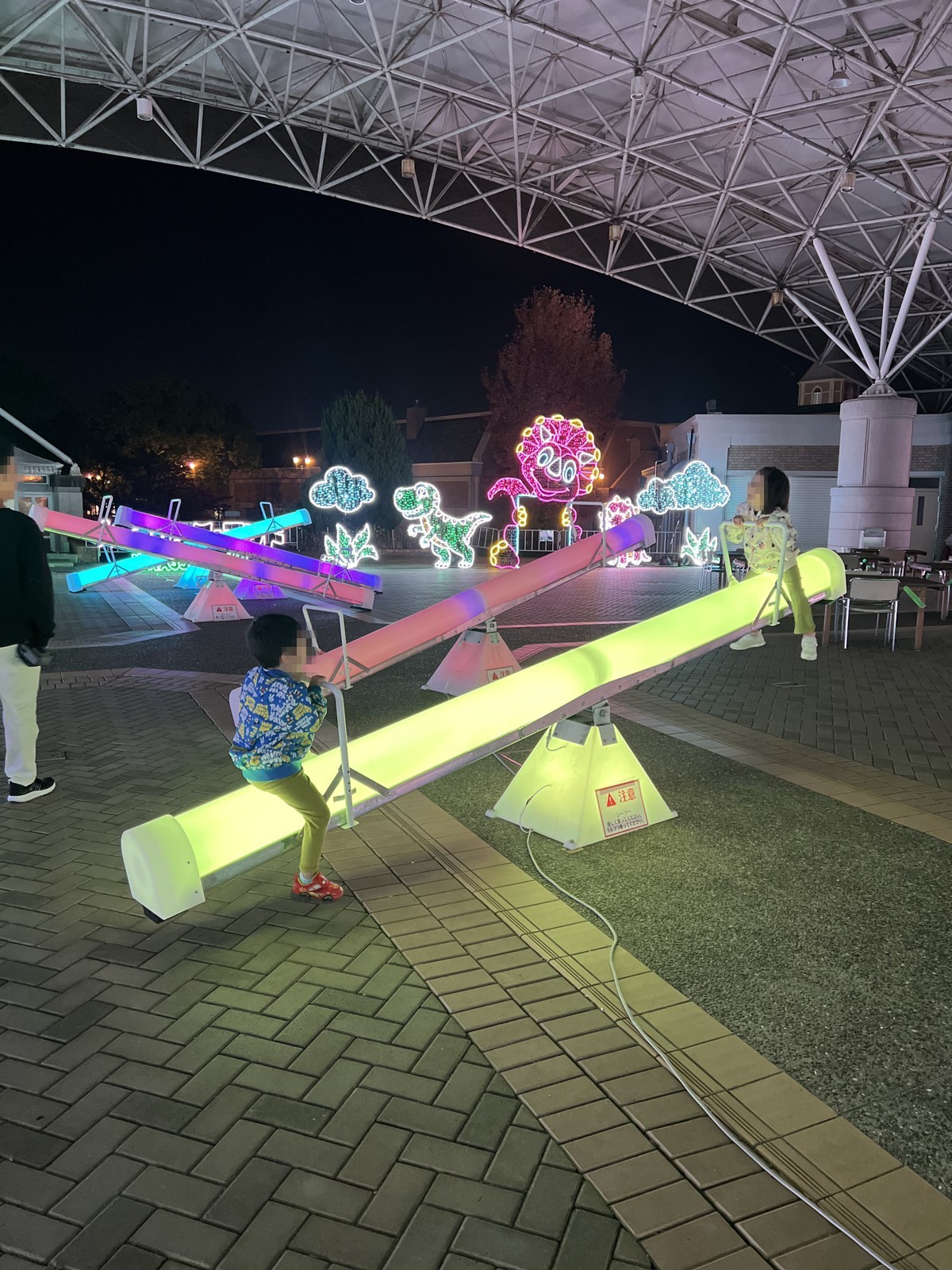 光るシーソーに乗る子ども