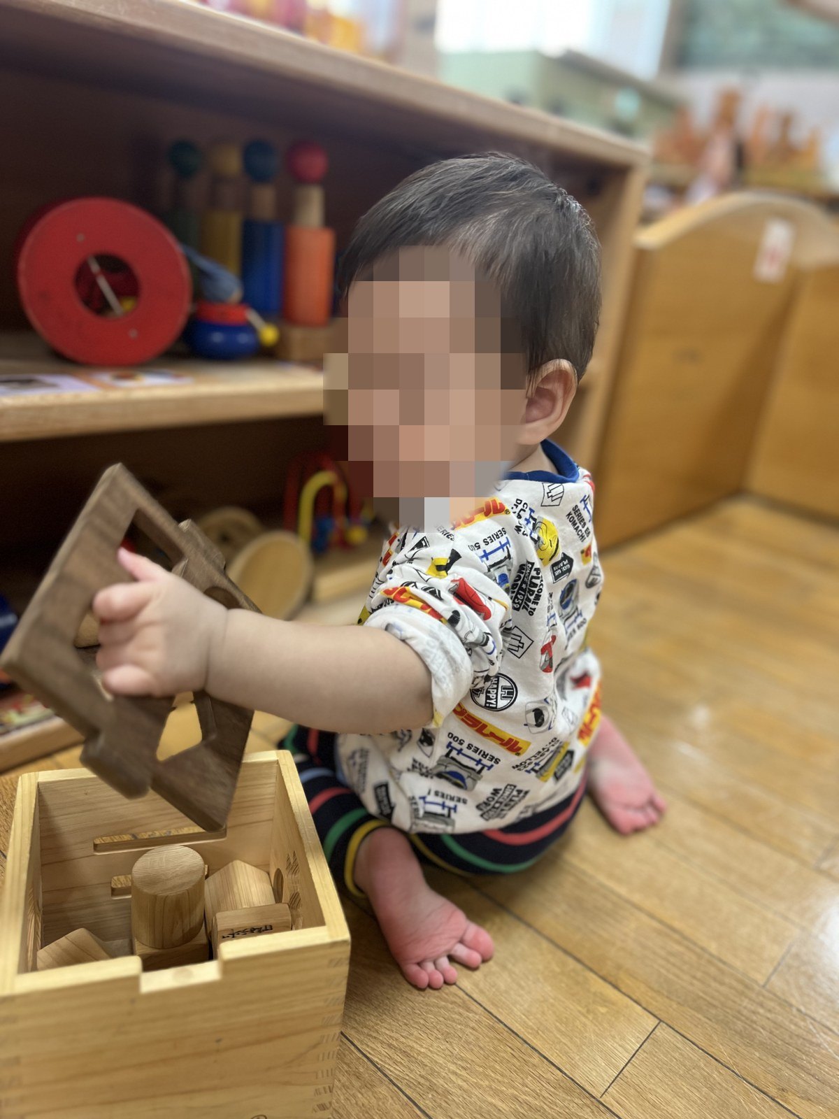 木のおもちゃで遊ぶ赤ちゃん