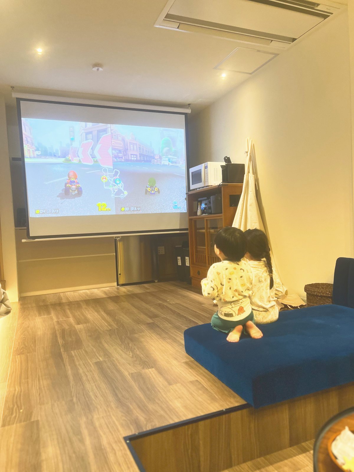 プロジェクターでマリオカートを映した画面を見る子どもたち