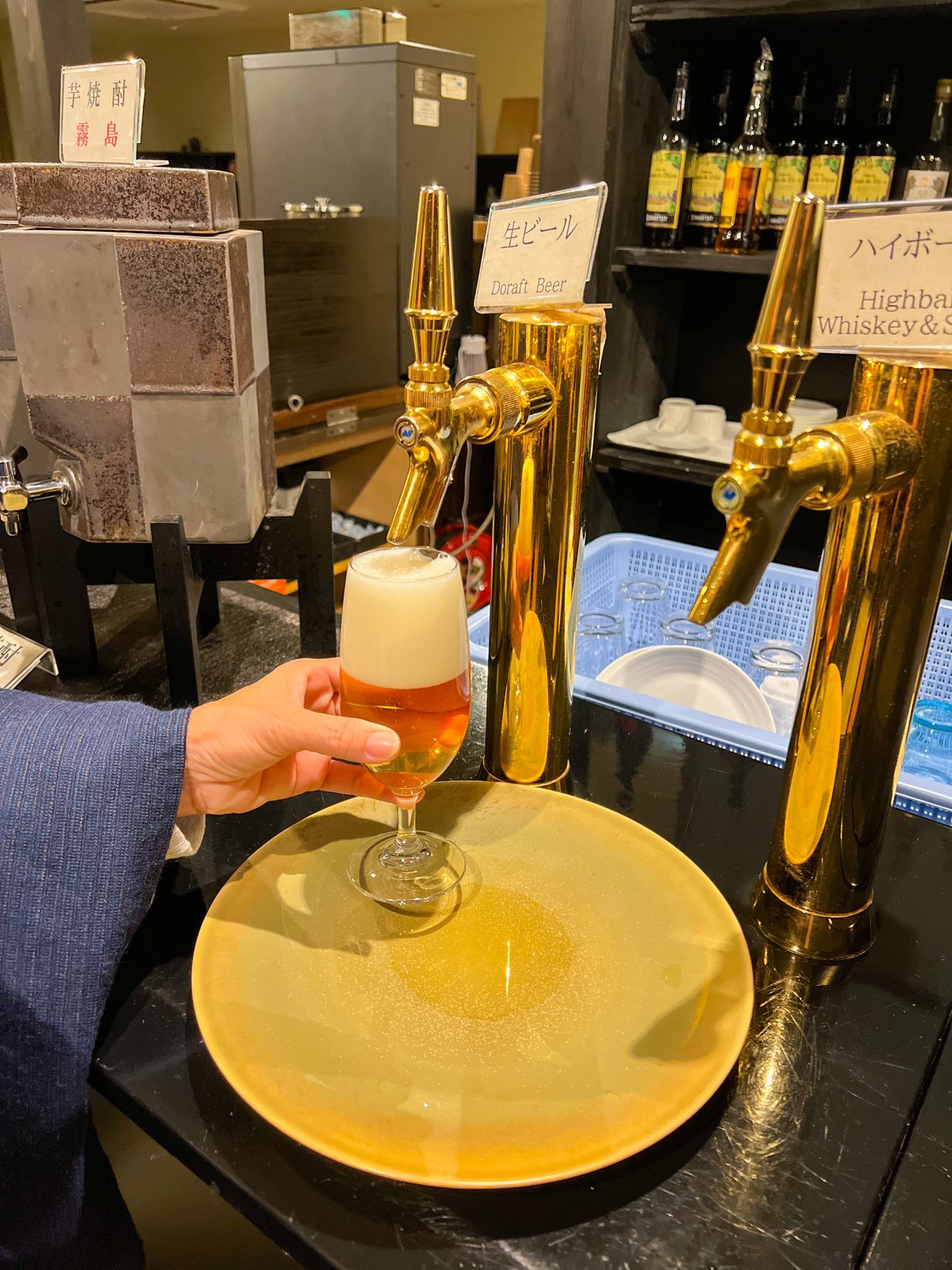 生ビールのサーバーからビールを注ぐ様子。隣には芋焼酎とハイボールのサーバー