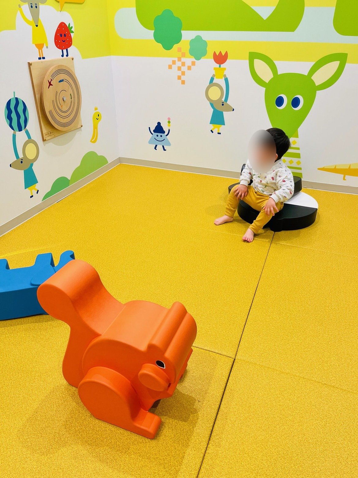 黄色い床のキッズスペースに置かれた動物の遊具