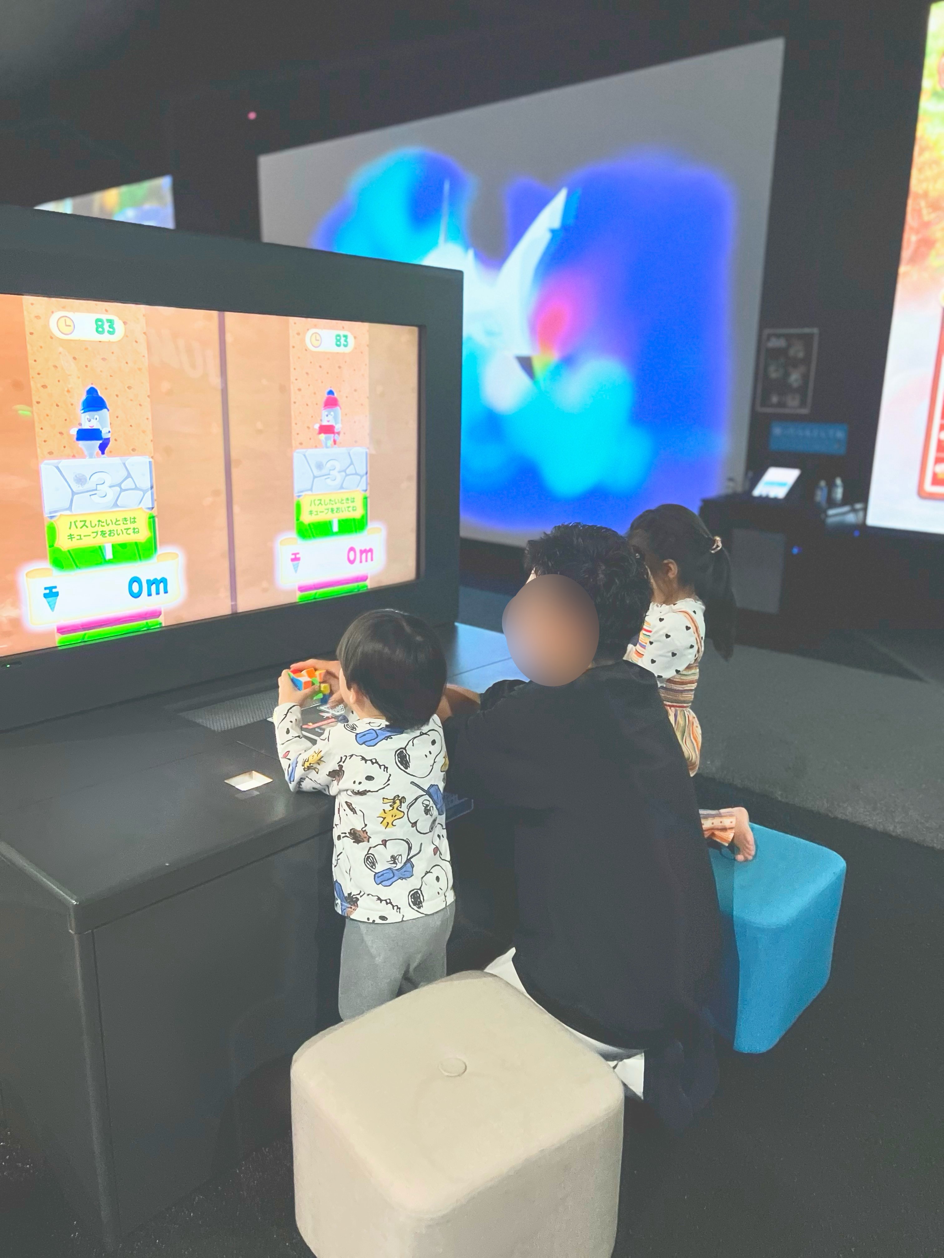 ブロックを使って画面のゲームで遊ぶ親子
