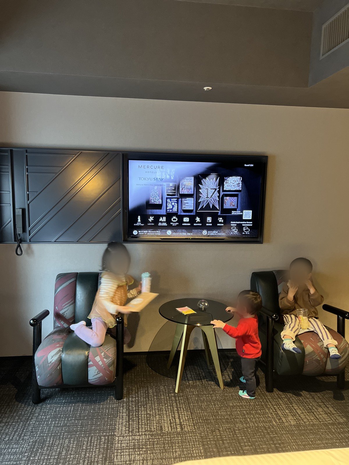 テレビの前の一人がけのイスでくつろぐ子どもたち