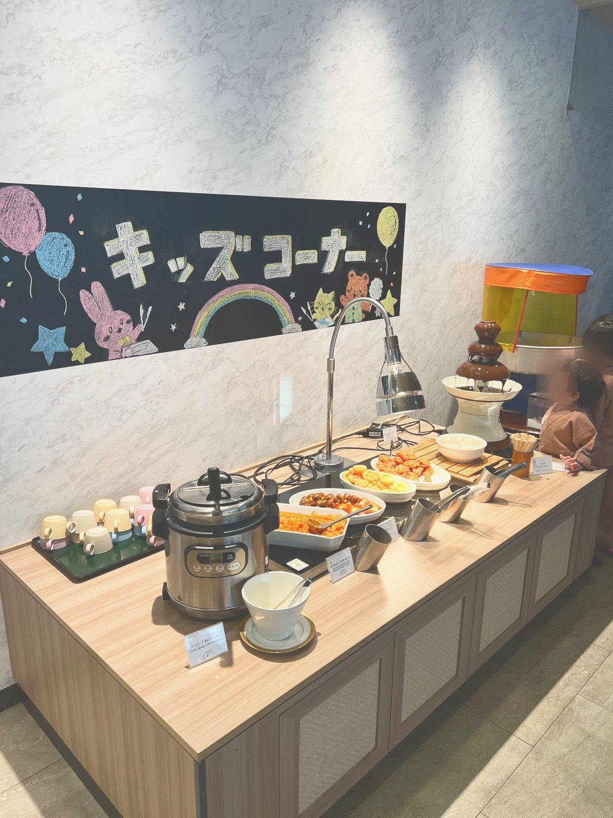 「キッズコーナー」の看板と、子ども向けの料理が並ぶ台