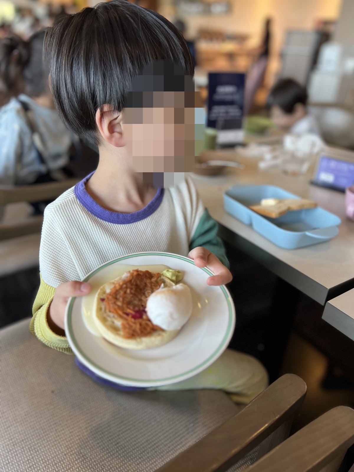 自分で取ってきた料理をお皿にのせた子ども