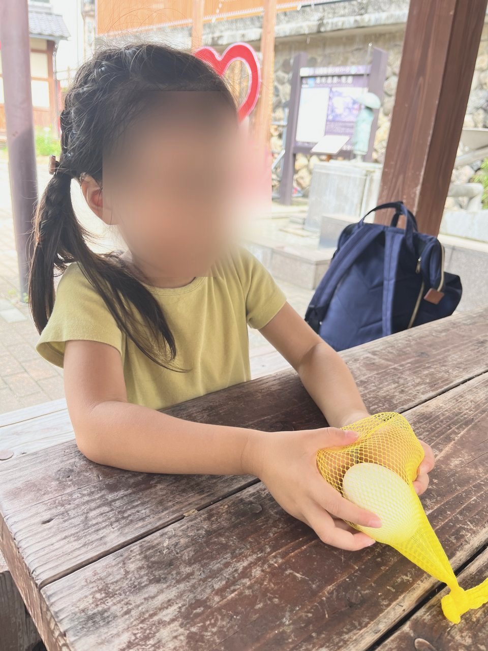 網に入ったゆでたまごを持つ子ども