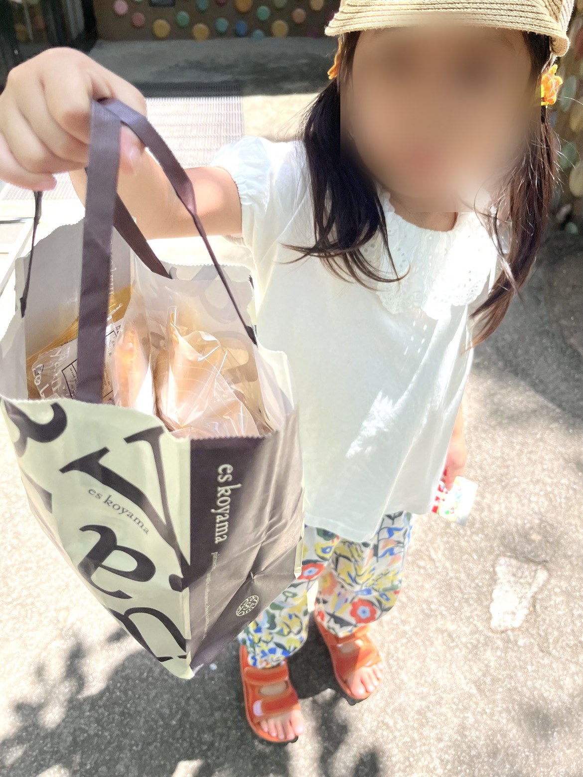 買ってきたパンの袋を見せる子ども