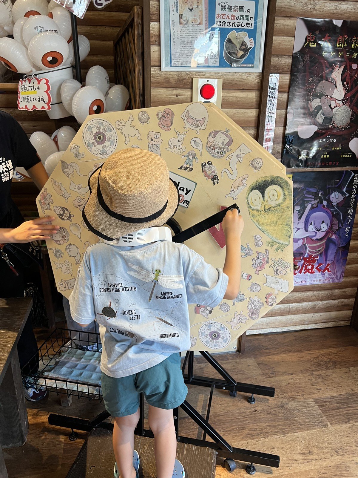 妖怪の絵が描かれたガラガラ(くじ)を回す息子