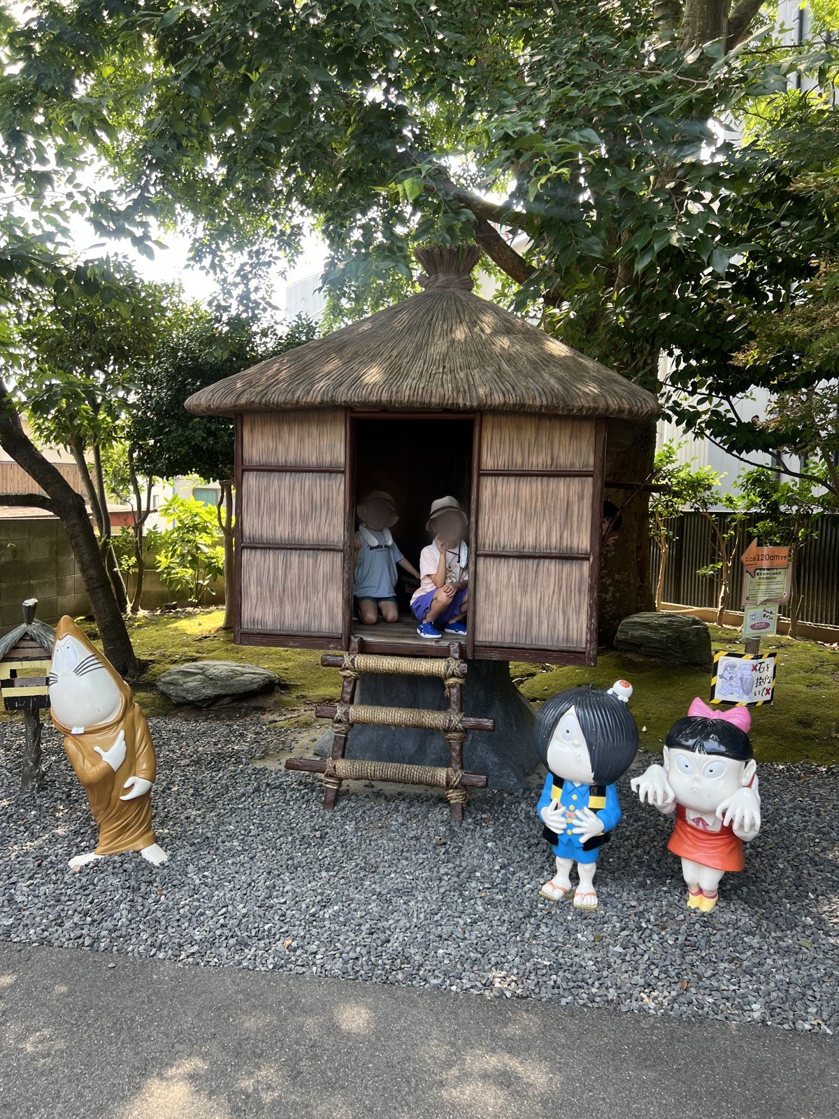 木の下にある、わらぶき屋根の小屋。前には鬼太郎たちの像