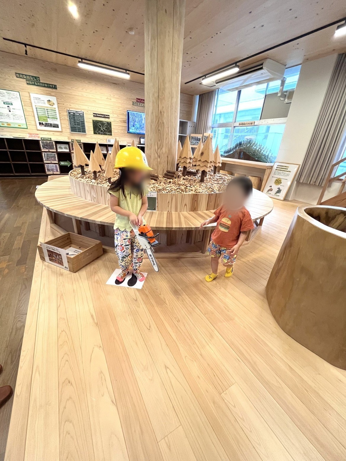 ヘルメットをかぶって展示台で遊ぶ子どもたち