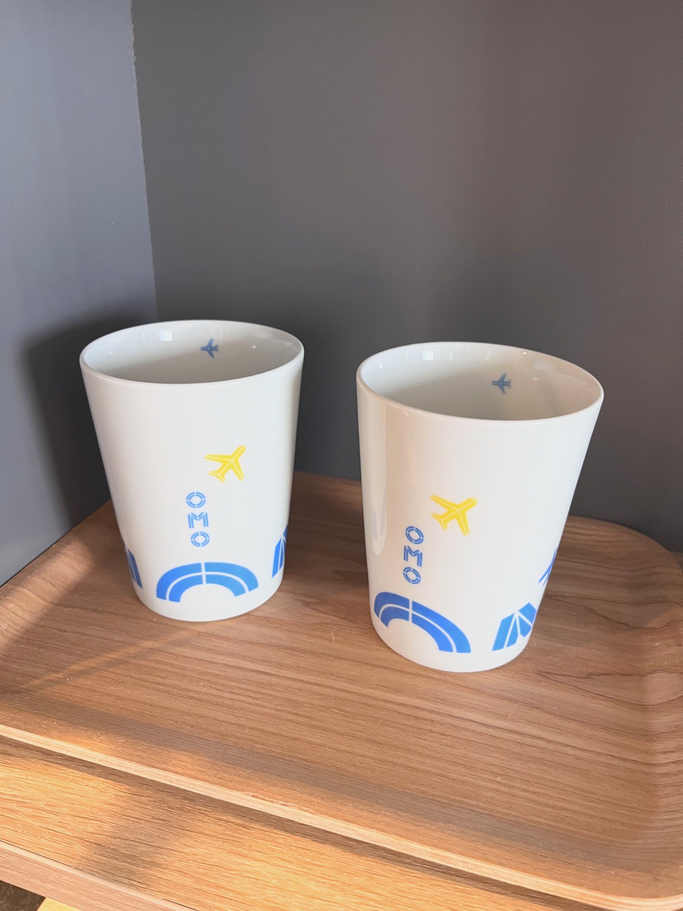 飛行機と滑走路の柄が入ったOMOのカップ2つ
