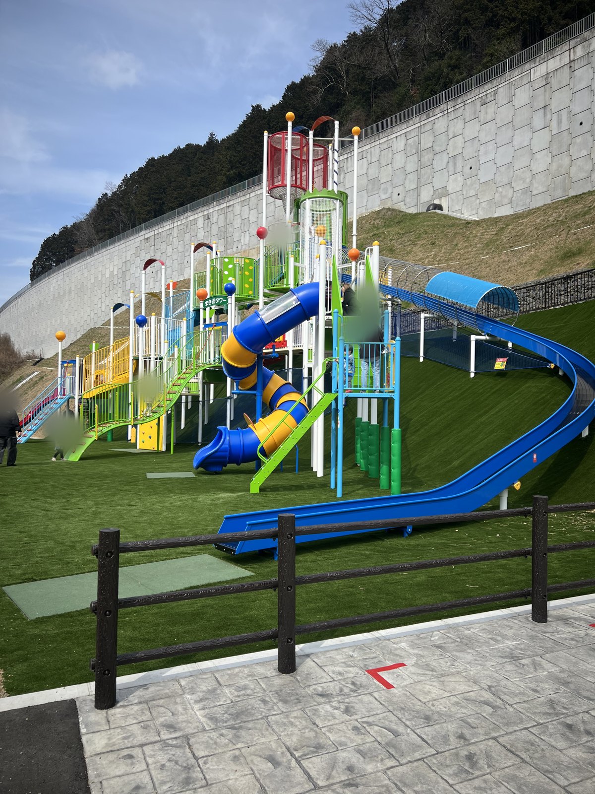 芝生の斜面に建つ「まきおタワー」。チューブすべり台と長いローラーすべり台がついている