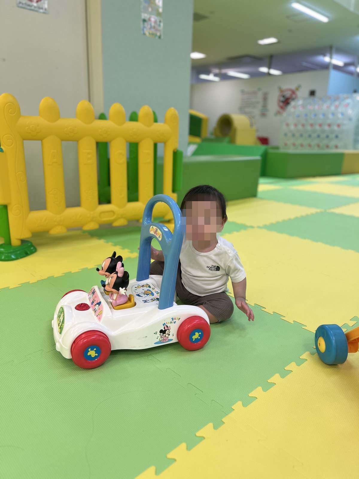 小さい子が手押し車のおもちゃで遊ぶ様子