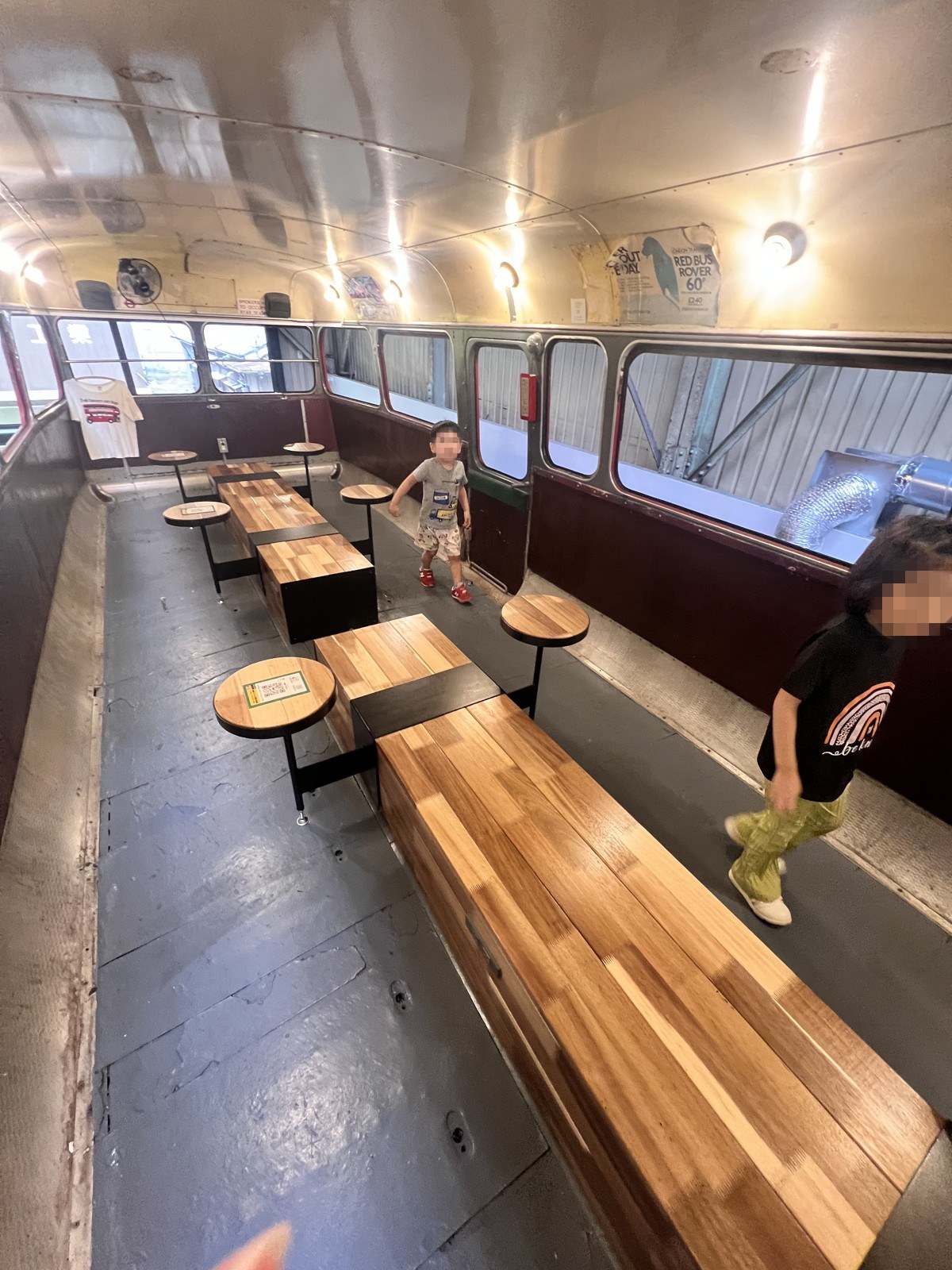 ロンドンバスの車内。長いベンチと丸テーブルが並んでいる