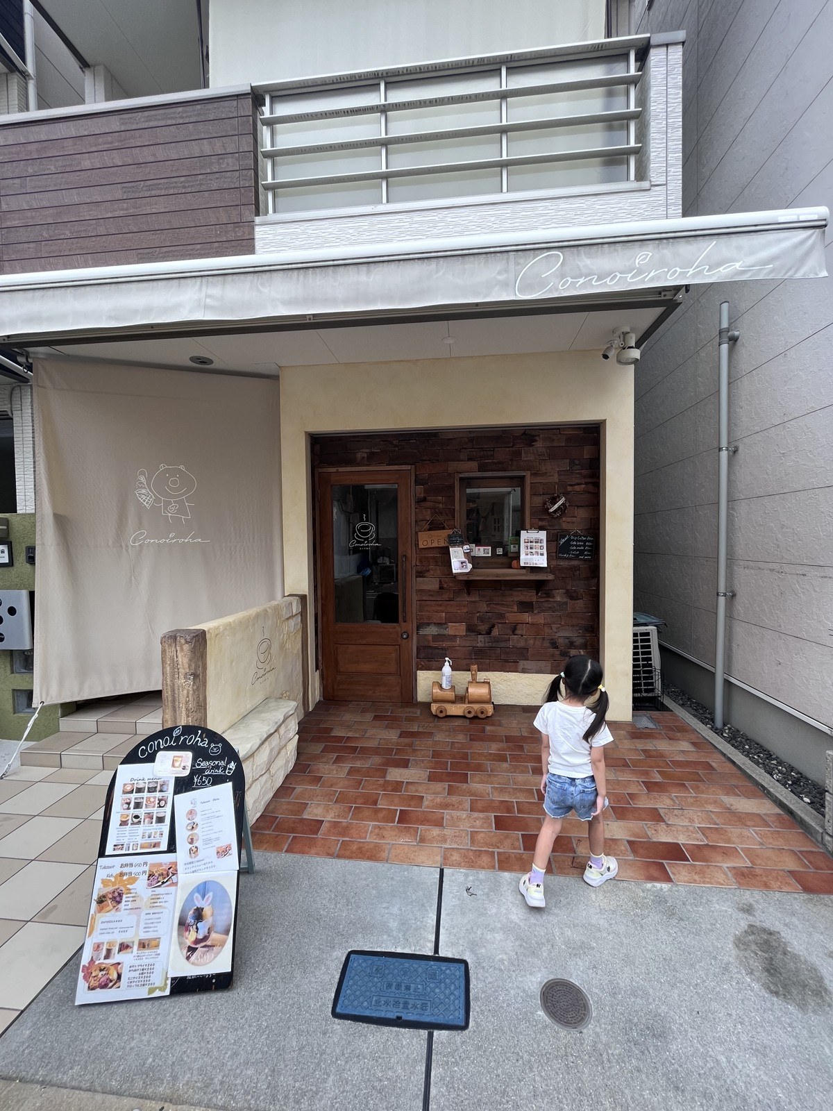 白い壁に木の看板が下がるコノイロハの入口