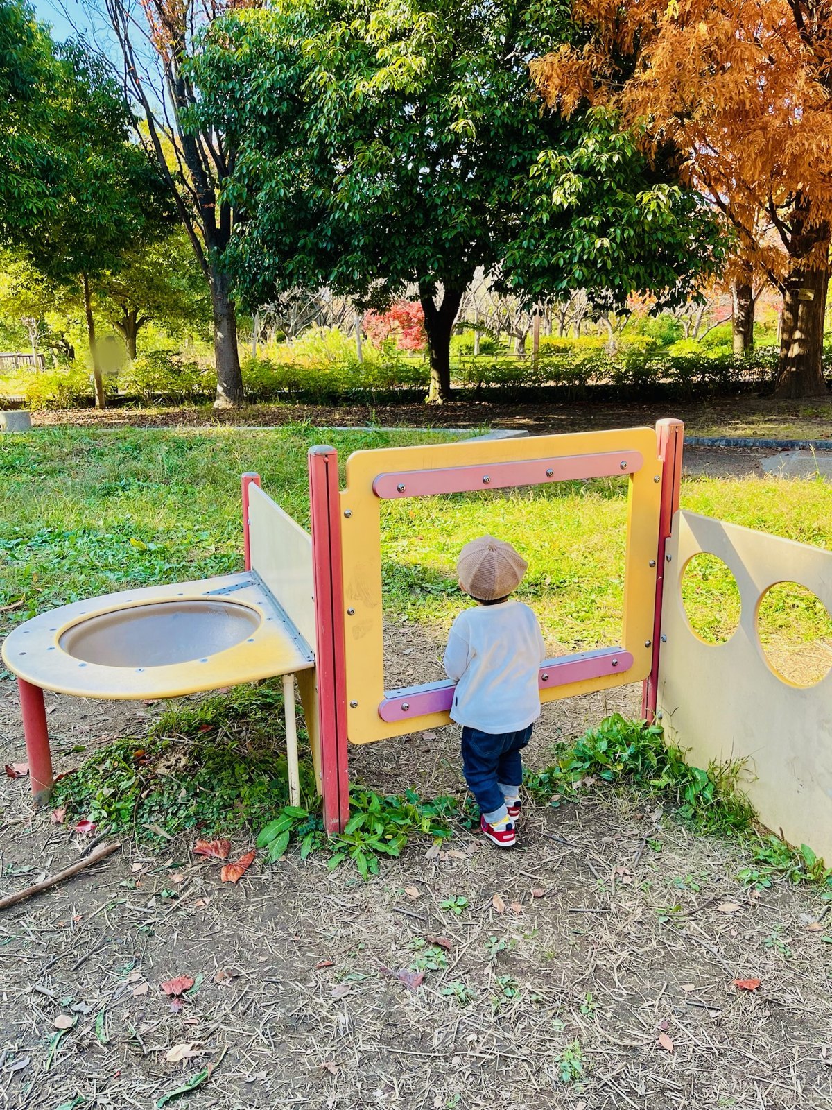 小さい子向けのパネル遊具の窓から外をのぞく次男