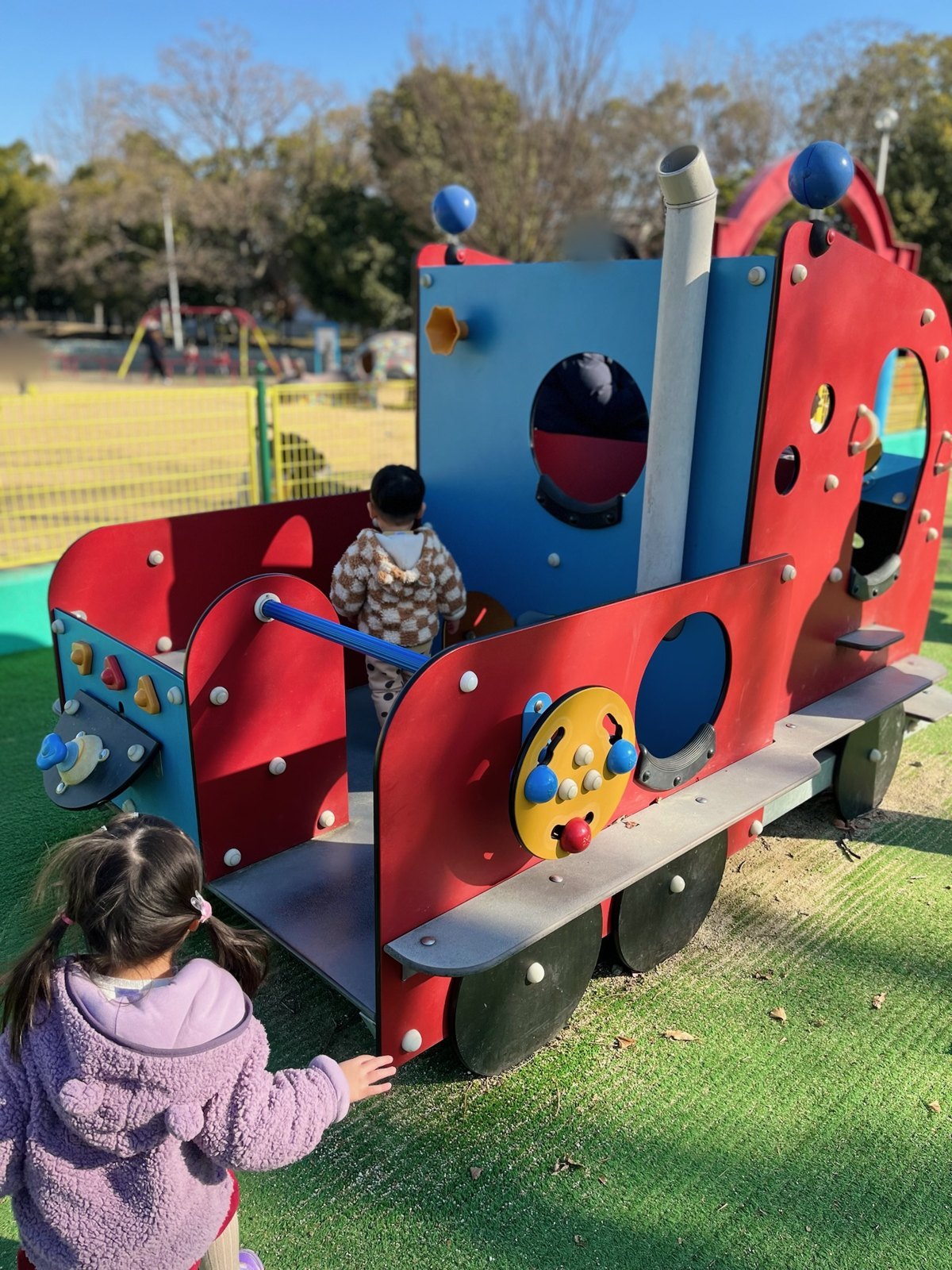 汽車の形をした小さい子向けの遊具で遊ぶ長女と次男