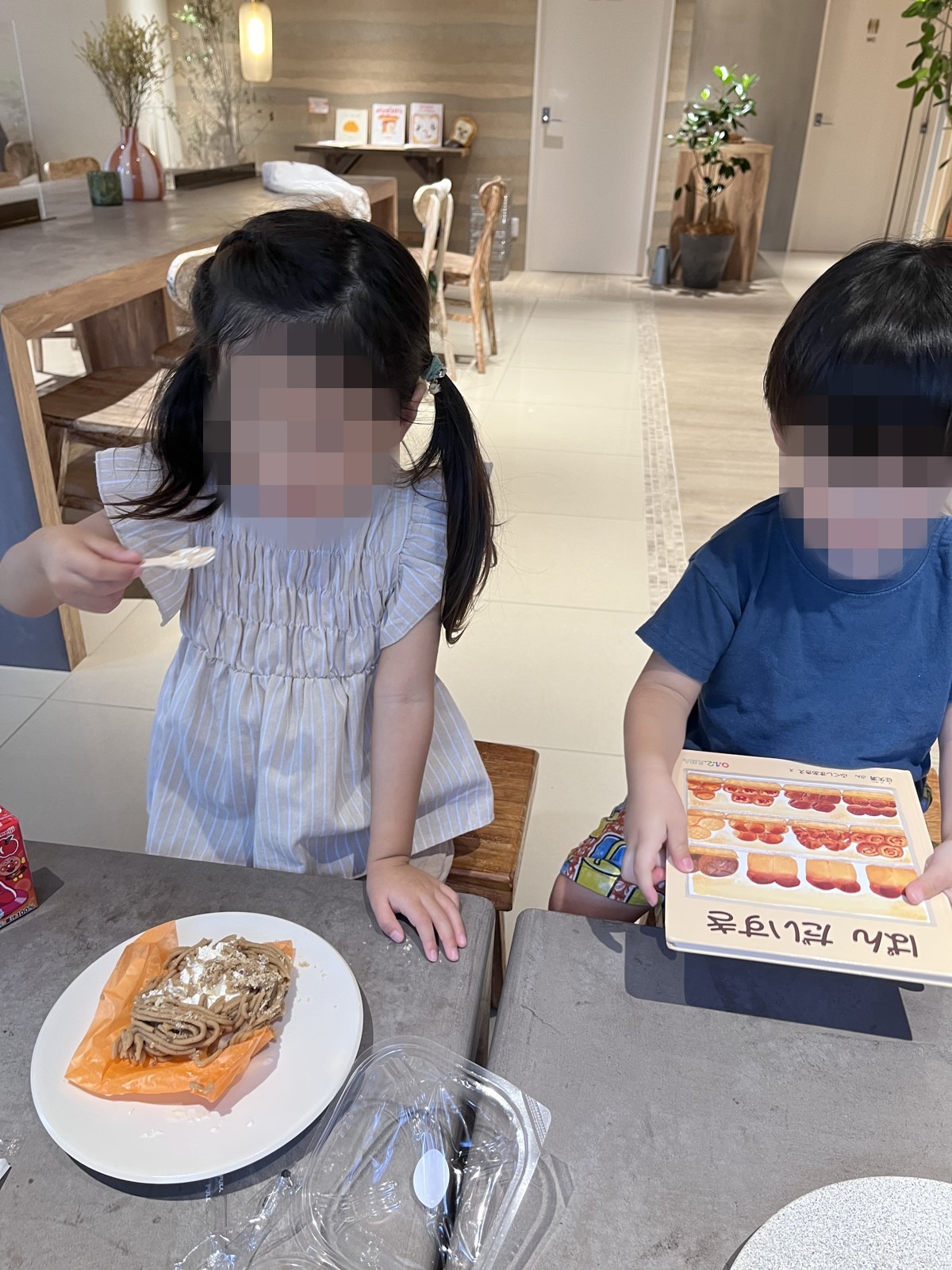 テーブルでパンを食べる子どもたち