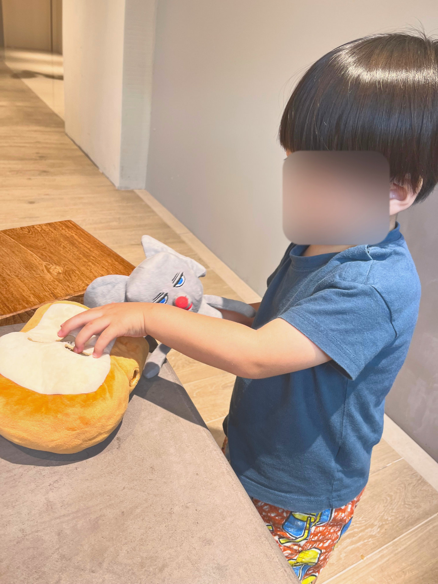 パンのぬいぐるみで遊ぶ子ども