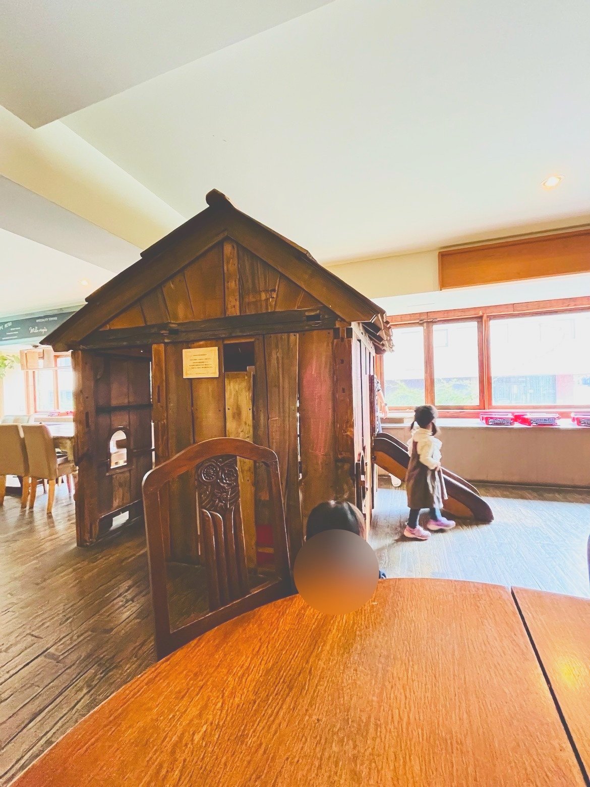 滑り台のある小屋のそばで遊ぶ子ども