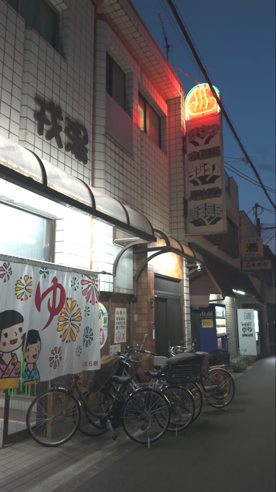 「ゆ」の暖簾が掛かった銭湯の外観